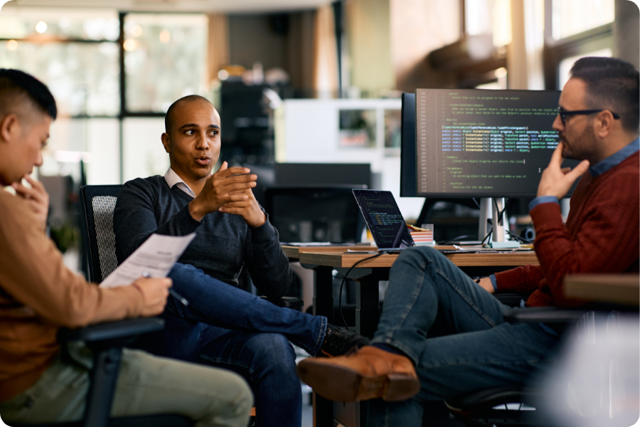 Tech startup team collaborating in a modern office with code on screen, representing Rise Accounting's advisory partnership with technology companies