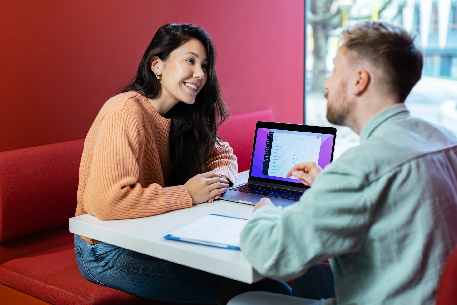 Rise Accounting team consulting with a startup founder over a laptop showing a financial dashboard.